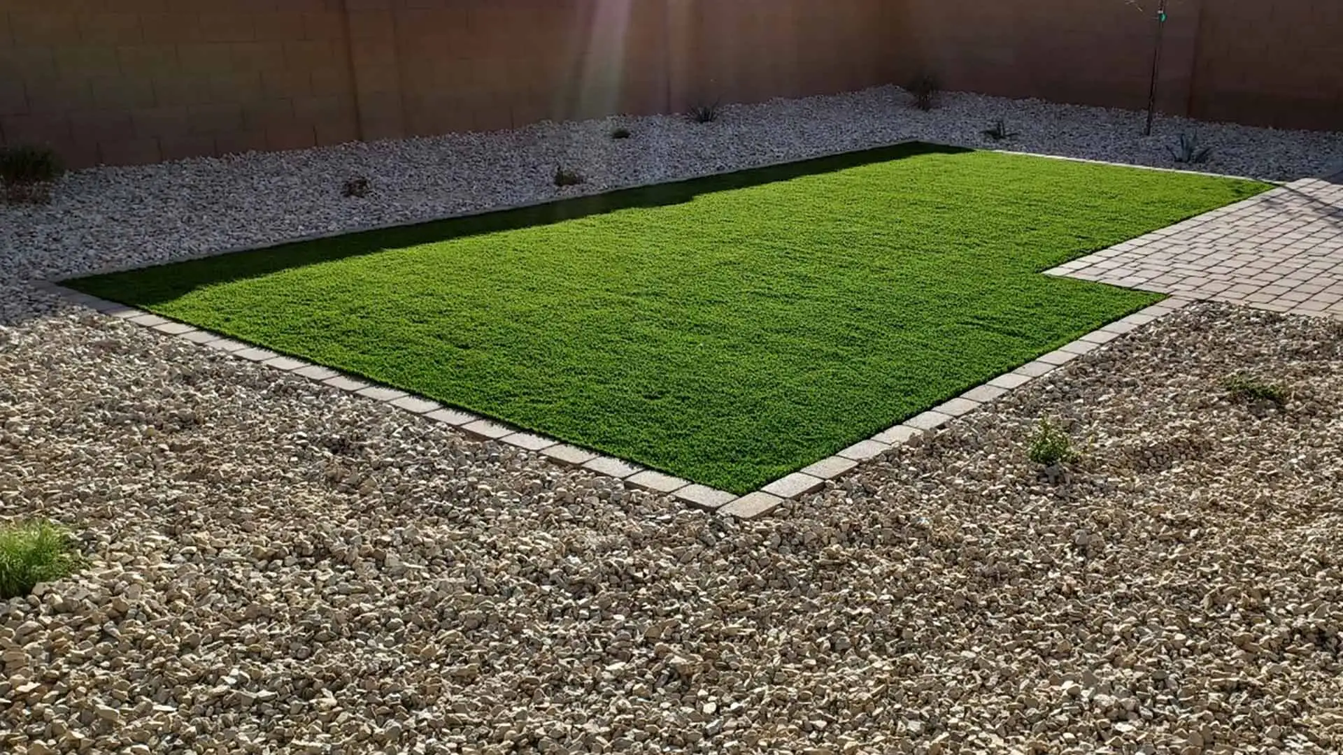 Artificial turf installed beside rock landscaping in Laveen, AZ.