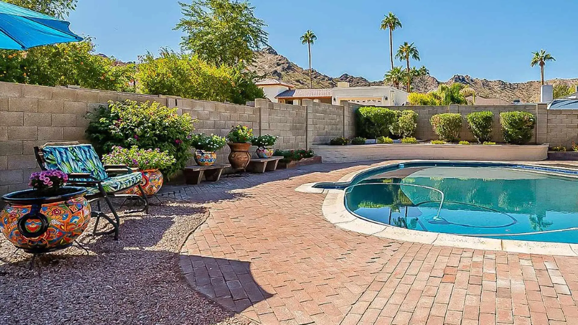 Patio beside pool with retaining wall installed in Peoria, AZ.