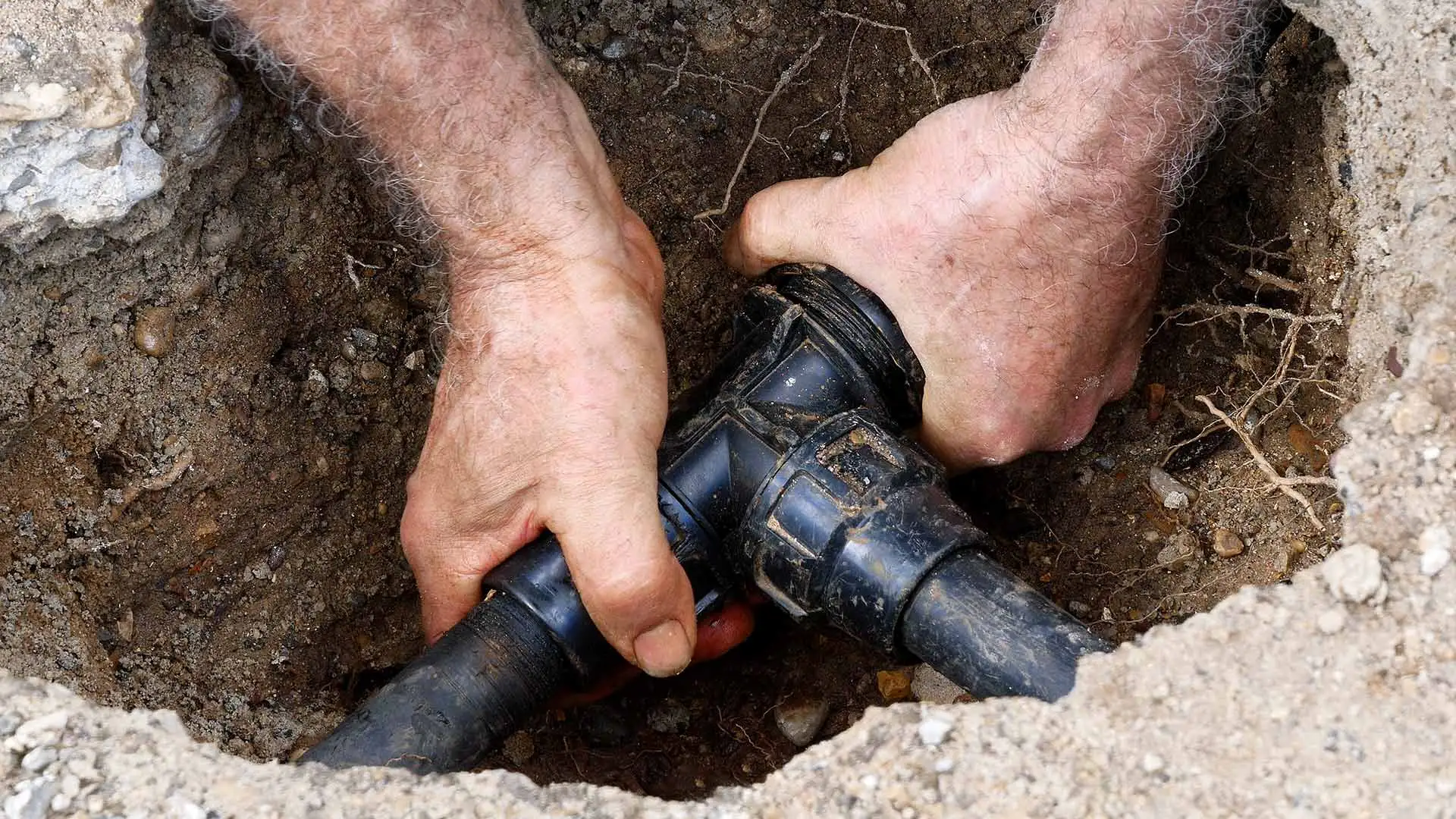 Technician repairing a broken irrigation pipe in Phoenix, AZ.