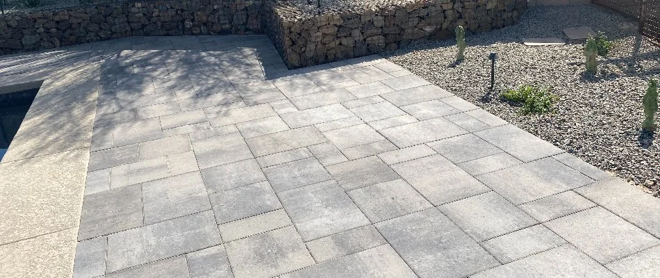Paver patio in Cave Creek, AZ, next to a stone wall.