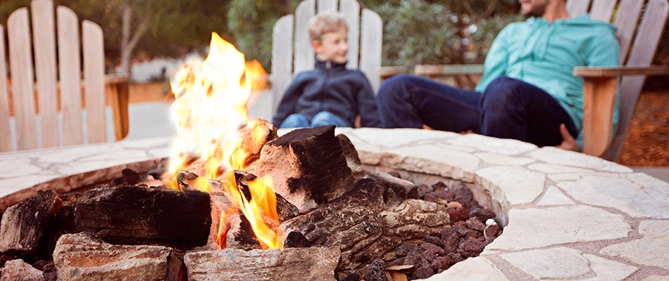 Father and child by a wood burning fire pit in Phoenix, AZ.