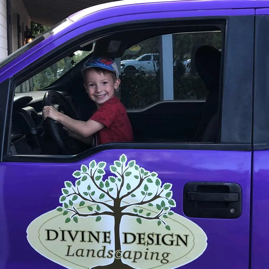 Young boy in Divine Design Landscaping work truck with logo in Phoenix, AZ.